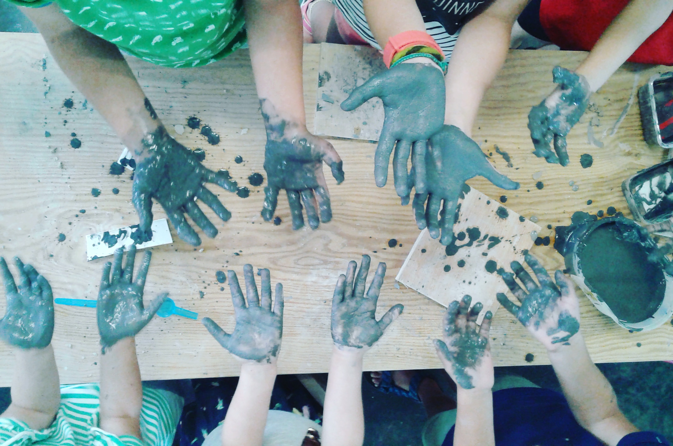 kinderen met handen vol gietklei tijdens een ontwerp kampje bij Rik Verhaest